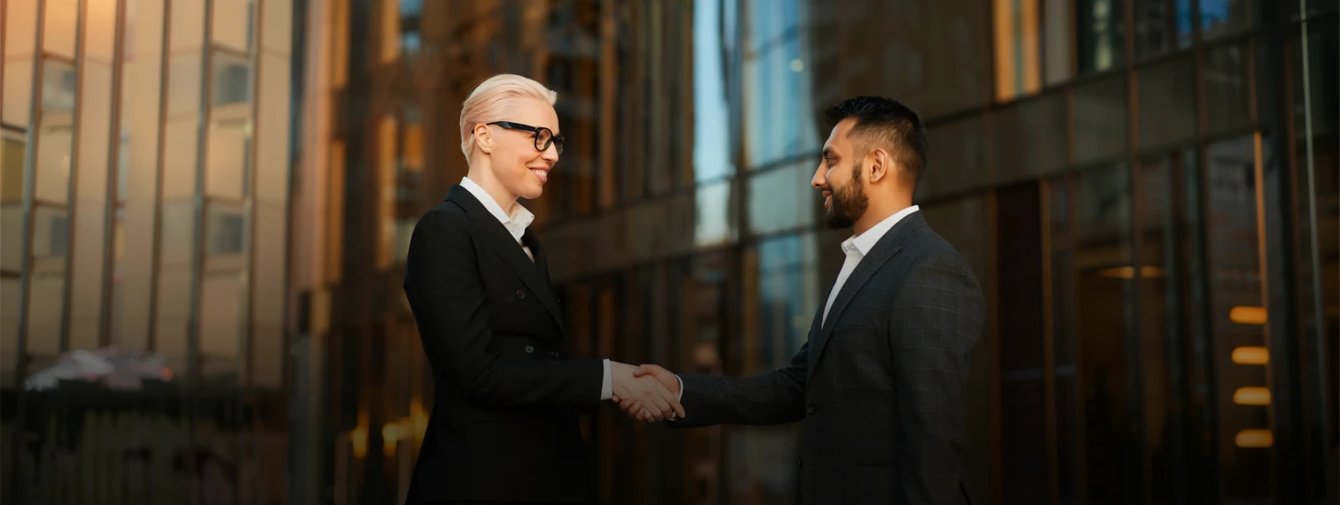 Enterprise stakeholders shaking hands outside an office tower